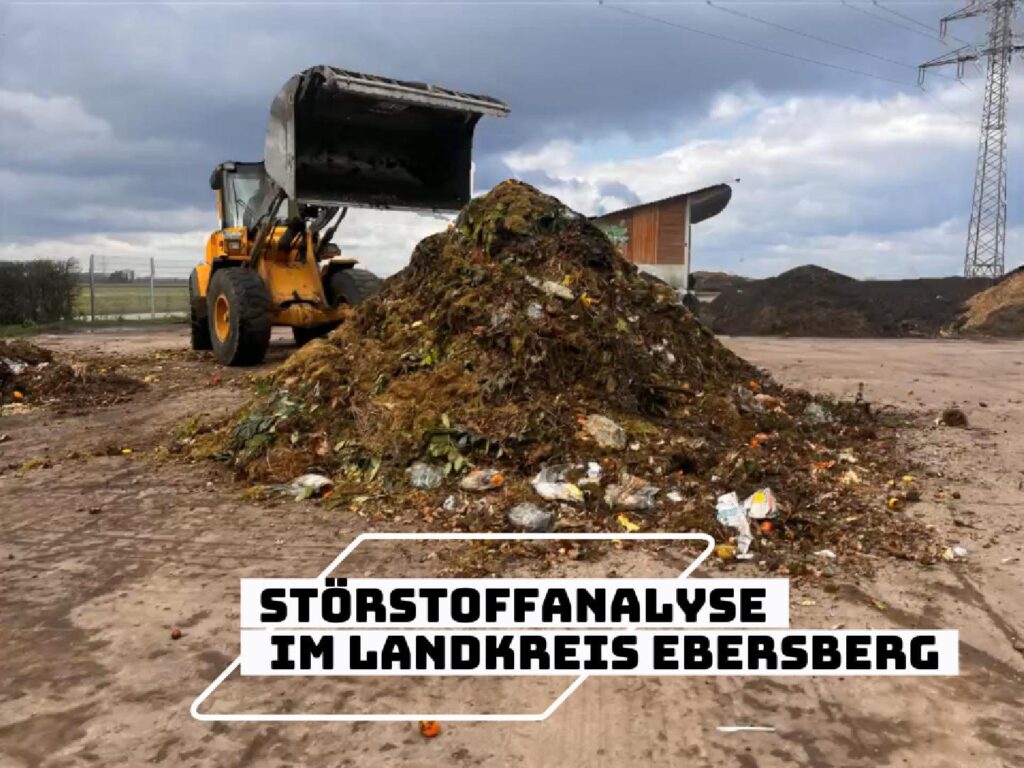 Coverbild eines Videos zur Störstoffanalyse im Landkreis Ebersberg. Zu sehen ist ein großer Haufen Bioabfall mit sichtbaren Störstoffen wie Kunststoffverpackungen auf einem Komposthof. Daneben steht ein Radlader mit angehobener Schaufel. Auf dem Bild ist der Schriftzug „Störstoffanalyse im Landkreis Ebersberg“ eingeblendet.